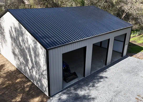 Steel residential garage with dark roof and open doors